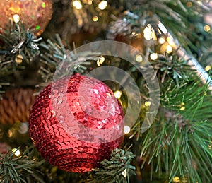 Christmas decorations on xmas tree with hanging balls and ornaments and bokeh background