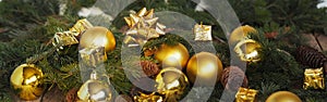 Christmas decorations yellow balls, fir branches on a wooden background with copy space. Gold style.