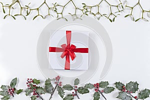 Christmas decorative background corner with red ribbon gift and decorations, holly, mistletoe aon white