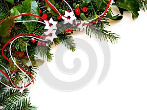 Christmas decorative background for greeting card, twigs of spruce and mistletoe with holly leaves and red balls, ribbon, cones