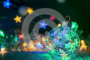 Christmas decorative glass ball against defocused garland lights