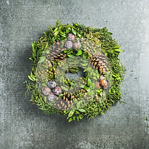 Christmas decorative wreath over grey concrete wall background, square crop