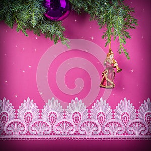 Christmas decorative pink background with lace and statuary of a