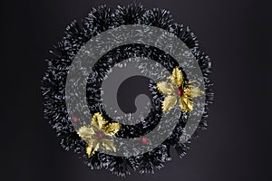 Christmas decorative wreath with golden floral top view on black background. Winter Holiday season backdrop