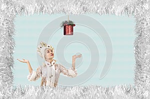 Christmas design-Christmas card with a beautiful, young, smiling woman dressed as Santa Claus, bordered by pine needles with a