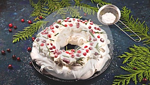 Christmas dessert Pavlova - meringue with whipped cream garnished with cranberries and rosemary. photo