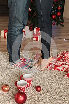 Christmas details. legs of couple on beige carpet