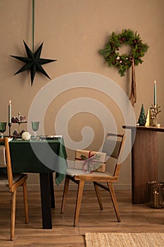 Christmas dining room interior with table, green tablecloth, wooden console, christmas wreath, chair, gifts, candle with