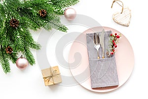 Christmas dinner decoration with gift box, plate and fir tree white table background top view