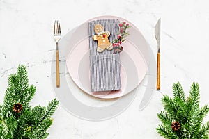 Christmas dinner decoration with gift box, plate and fir tree white table background top view