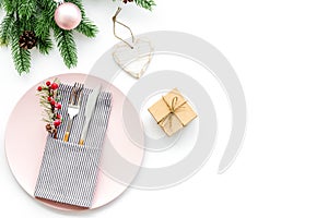 Christmas dinner decoration with gift box, plate and fir tree white table background top view mock-up