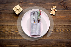 Christmas dinner decoration with gift box, plate and fir tree wooden table background top view