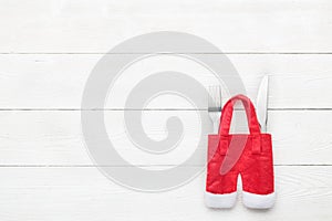 Christmas dinner table setting with fork, knife on white wooden texture. Flat lay