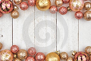 Christmas double border of rose gold and golden ornaments on white wood