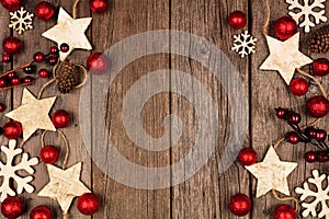 Christmas double side border with wood star ornaments and red baubles, top view over rustic wood