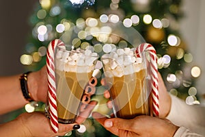 Christmas drink. Cup of hot chocolate with marshmallows and red candy cane on festive background