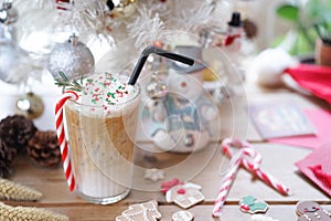 Christmas drink. A cup of iced coffee peppermint latte with candy cane and rosemary, a seasonal drink during December