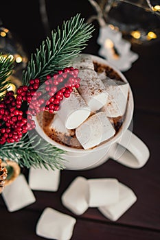 Christmas drink hot chocolate with marshmallows at festive illuminated decoration. Selective focus