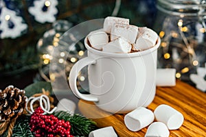 Christmas drink hot chocolate with marshmallows at festive illuminated decoration. Selective focus