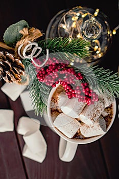 Christmas drink hot chocolate with marshmallows at festive illuminated decoration. Selective focus