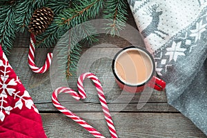 Christmas drink. Mug hot coffee with milk, red candy cane on the wooden background. New Year. Holiday card. Rustic style. Top view