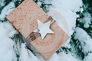 Christmas eco gift in rustic vintage style. Winter holidays mock up on snowy fir branch background. Zero waste, plastic