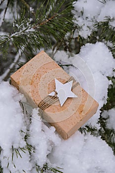 Christmas eco gift in rustic vintage style. Winter holidays mock up on snowy fir branch background. Zero waste, plastic