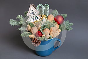 Christmas edible bouquet with nuts, sweets, nobilis and christmas decor in a blue cup