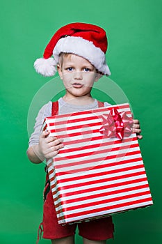 Christmas Elf holding big red gift box with ribbon. Santa Claus helper