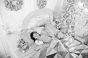 Christmas eve concept. Child waiting christmas in bedroom. Kid lay in bed relaxing. Home is the best place in the world