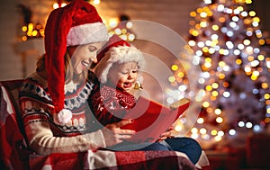 Christmas Eve. family mother and baby reading magic book at home