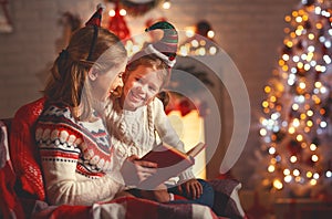 Christmas Eve. family mother and child daughter reading magic bo