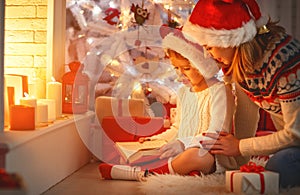 Christmas Eve. family mother and child daughter reading magic bo