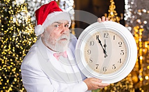 Christmas eve. Santa claus counting time. Midnight concept. New year countdown. Man with retro clock. Garland