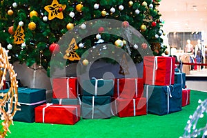 Christmas eve shopping mall decoration of tree and gifts traditional box with ribbon in central hall space