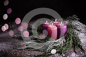 Christmas eve, wreath with four burning purple advent candles
