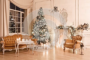Christmas evening by candlelight. classic apartments with a white fireplace, decorated tree, sofa, large windows and