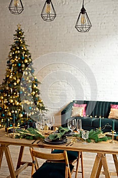 Christmas evening by candlelight. classic apartments with a white fireplace, decorated tree, sofa, large windows and