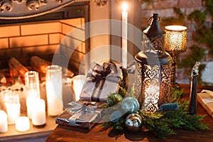 Christmas evening by candlelight. classic apartments with a white fireplace, decorated tree, sofa, large windows and