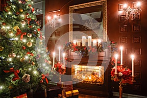 Christmas evening by candlelight. classic apartments with a white fireplace, decorated tree, sofa, large windows and