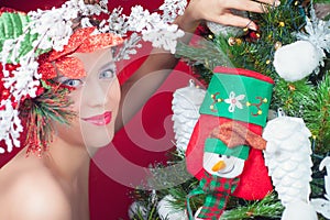 Christmas fairy woman with tree hairstyle decorating christmas tree