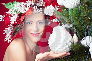 Christmas fairy woman with tree hairstyle decorating christmas tree