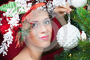 Christmas fairy woman with tree hairstyle decorating christmas tree