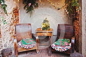 Christmas family garden or front porch. Rustic boho outdoor decor and old wooden table and armchairs