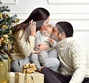 Christmas Family with Kid and gold present gifts. Happy kissing