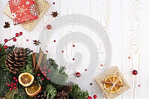 Christmas festive background with fir tree decorated with pinecone, beads and gifts wrapped in kraft paper, dried