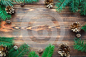 Christmas festive background, space for invitations and greetings, top view. Golden cones and fir tree branches