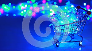 Christmas festive Christmas garland with colorful flashing lights and LEDs in a supermarket grocery cart