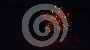 Christmas festive Christmas garland with colorful flashing lights and LEDs in a supermarket grocery cart