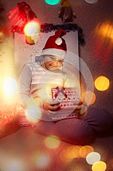 Christmas festive eve happy child with magic gift at home near Christmas tree and fireplace